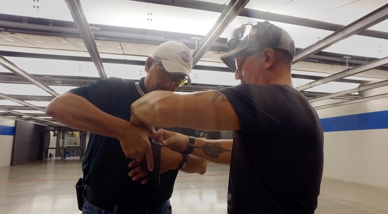Firearms instructor working with student